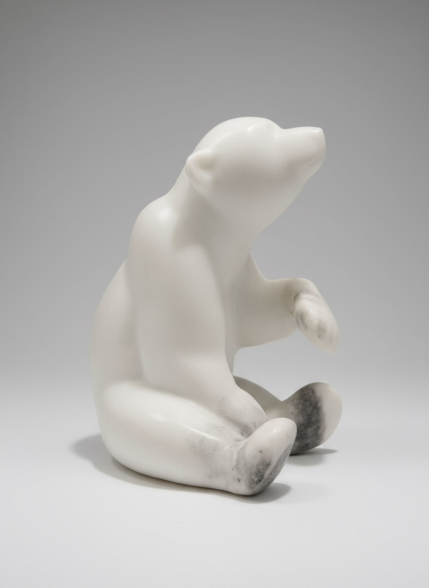 First Winter—a marble bear sculpture celebrating a cub's inaugural encounter with snow. Handcrafted in Whistler, BC from Italian white marble, this 8" x 6" x 9.5" piece weighs 18 pounds and captures the magic of that transformative moment. The luminous stone mirrors frost and ice, bringing the wonder and innocence of a young bear's first winter into your home.