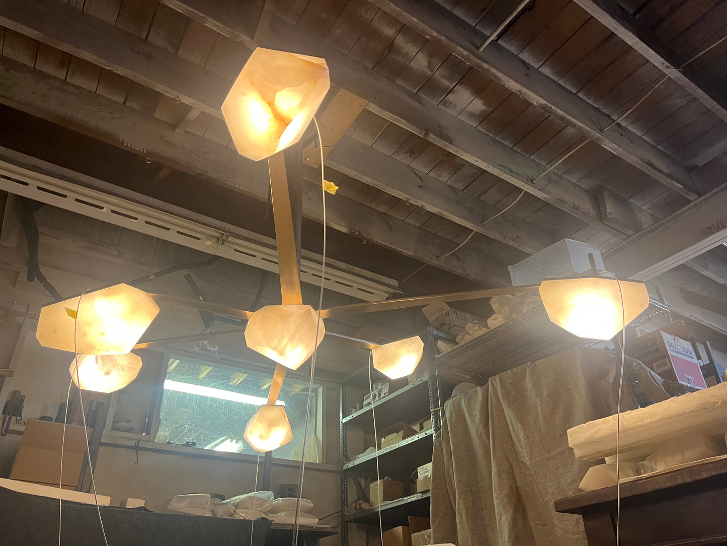 Hanging Stone Lights, interior design glowing stone light, art light, Hand carved alabaster lights, alabaster hanging modern lights, Polished Brass alabaster lights, Interior Lighting Design, Randy Zieber Lights, Custom Made Pendant Fixtures, High-end Stone Ceiling Lights, Alabaster globe pendants, Unique pendant lighting designs, Sculptural stone pendant lamps, Decorative pendant lights, Alabaster and brass pendants, Artistic stone pendant fixtures, Minimalist pendant lighting, Alabaster pendant clusters