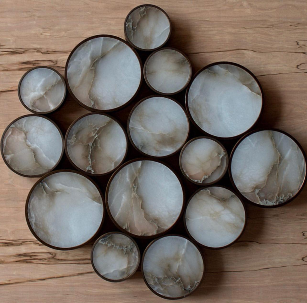 There are three sizes of these alabaster circle lights.  The patterns on the wall to hang these lights are limitless. These have antiqued bronze color metal circle that the alabaster is inlayed into.  Interior designers have asked us to organize these into star constellations like the big dipper / Ursa Major.