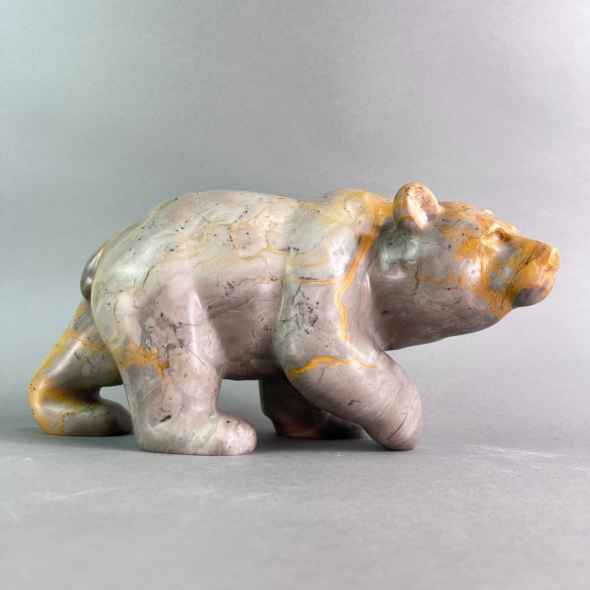 Stone sculpture of a bear on a gray background