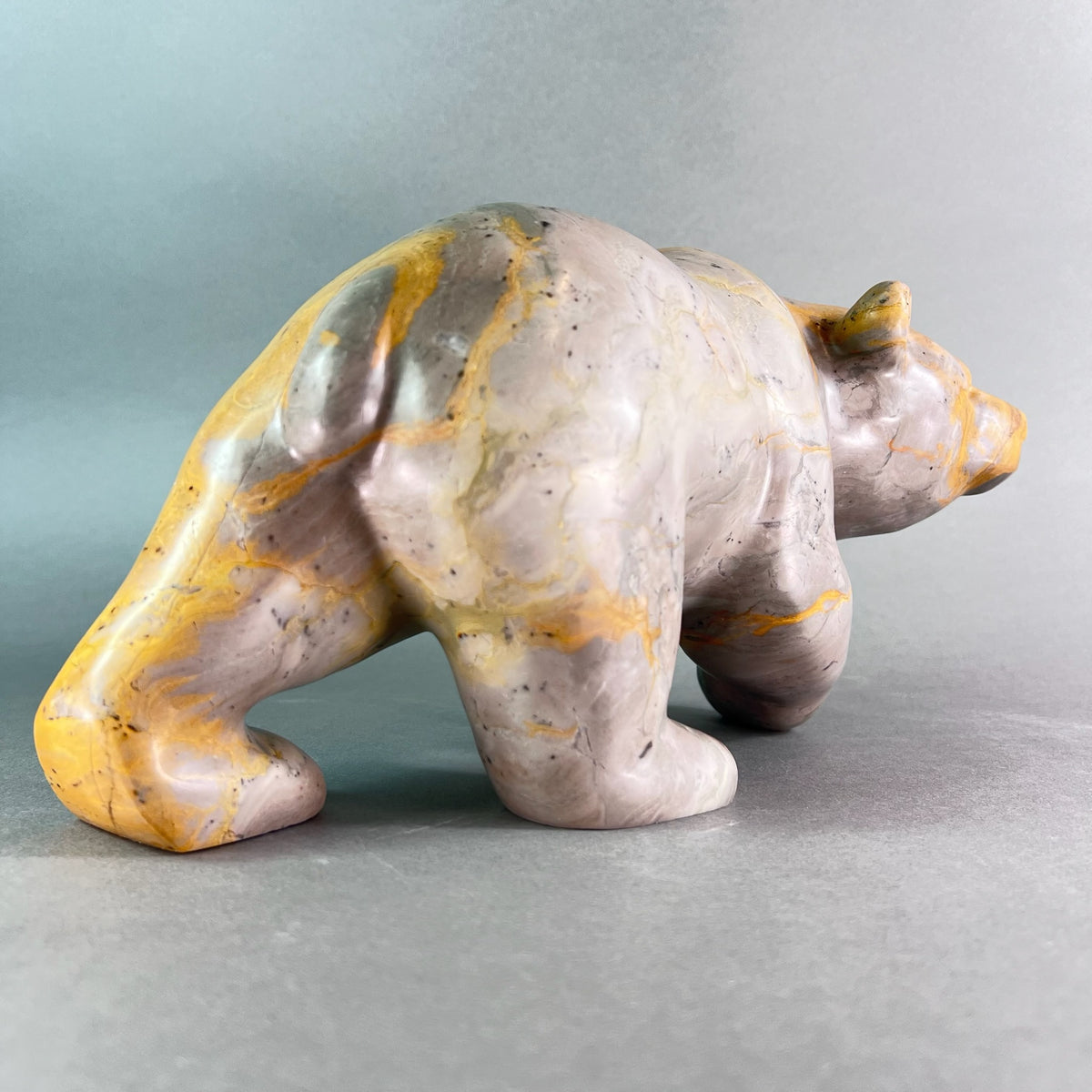 Marble-like bear sculpture on a gray background