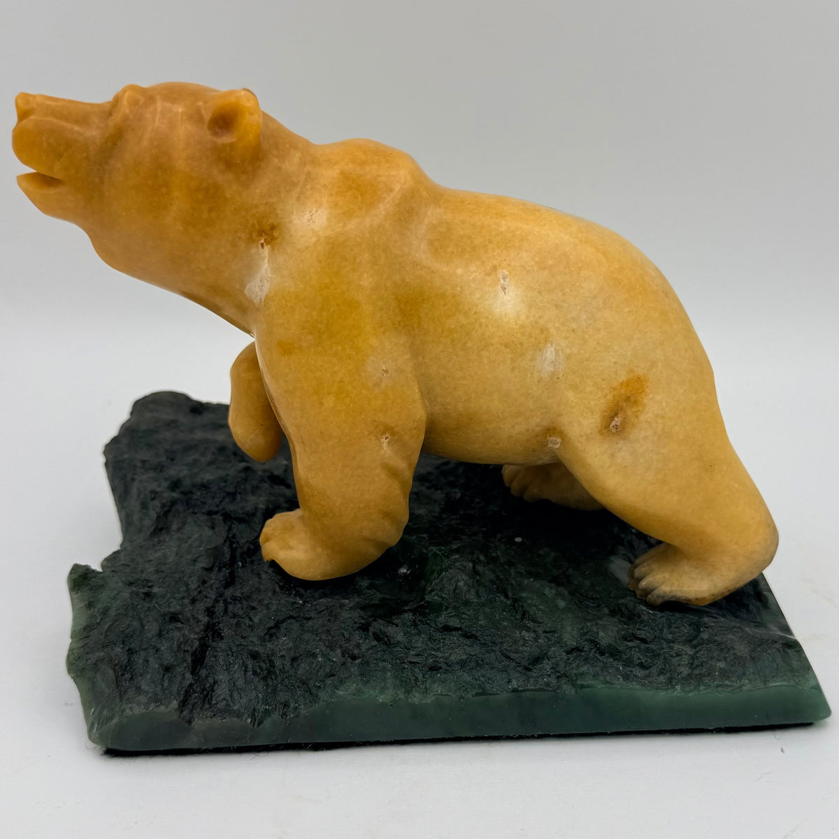 Bear sculpture on a jade base against a white background
