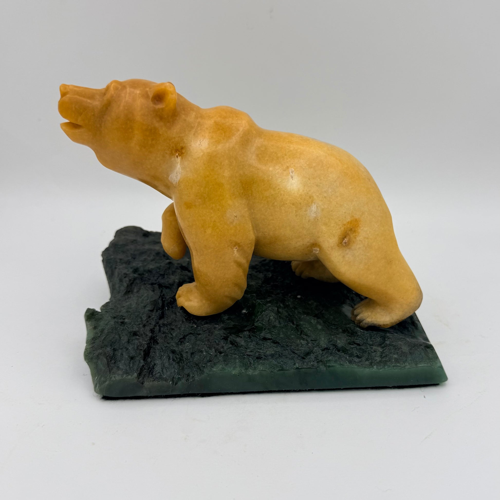 Bear sculpture on a jade base against a white background