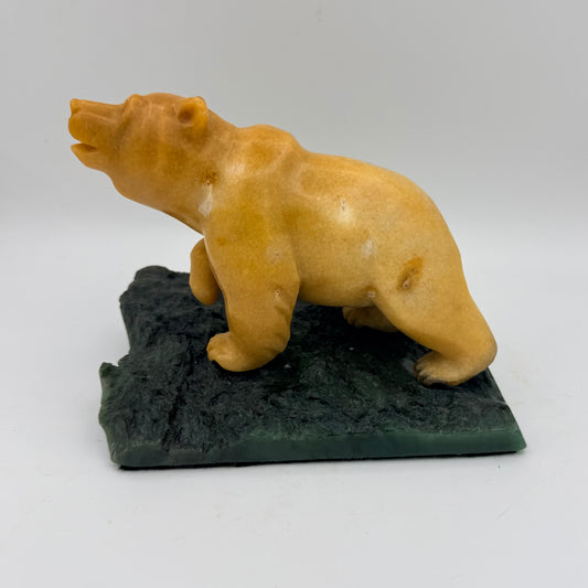 Bear sculpture on a jade base against a white background