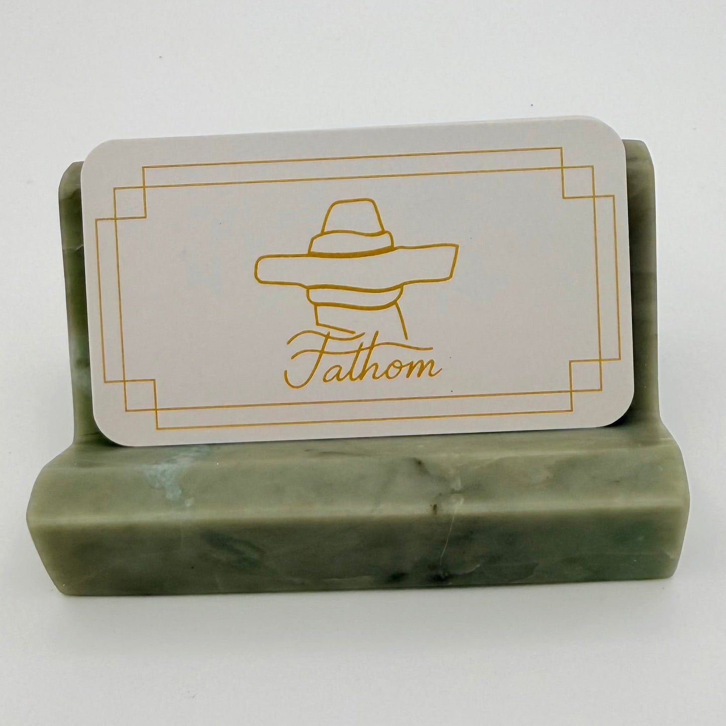 Green chlorite business card holder with a card featuring 'Fathom' branding on a white background