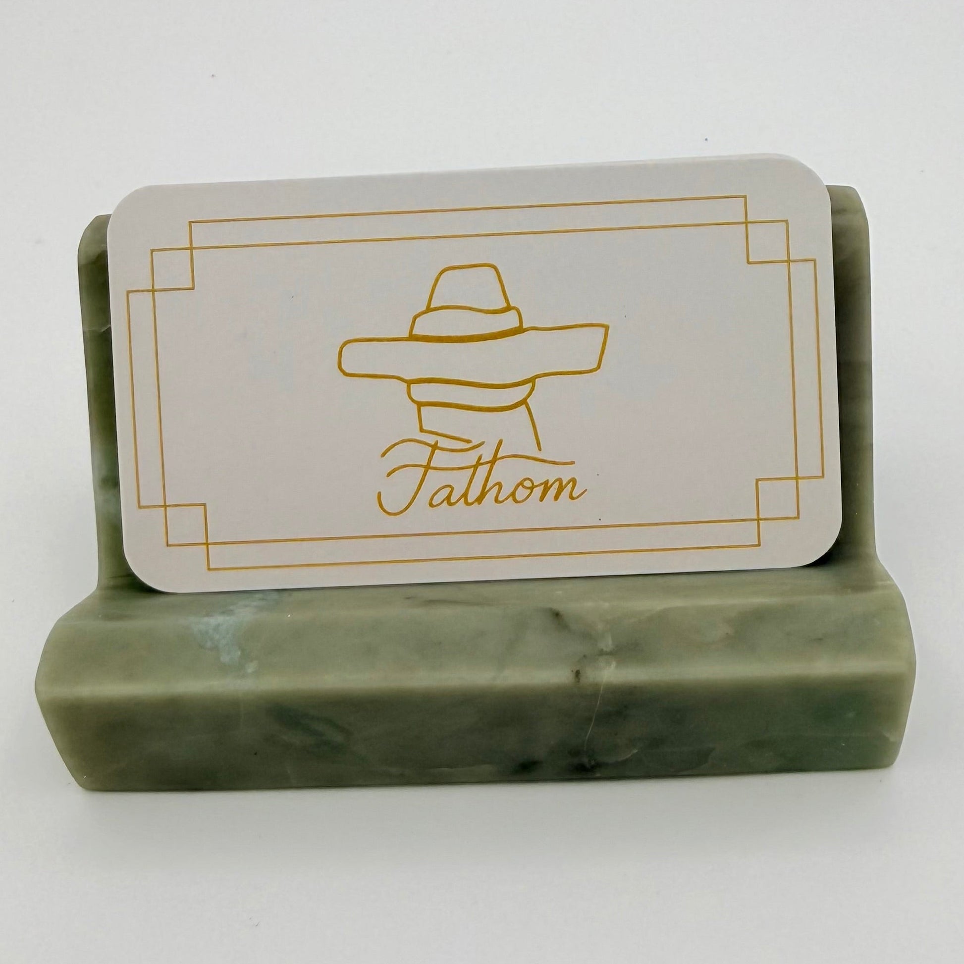 Green chlorite business card holder with a card featuring 'Fathom' branding on a white background