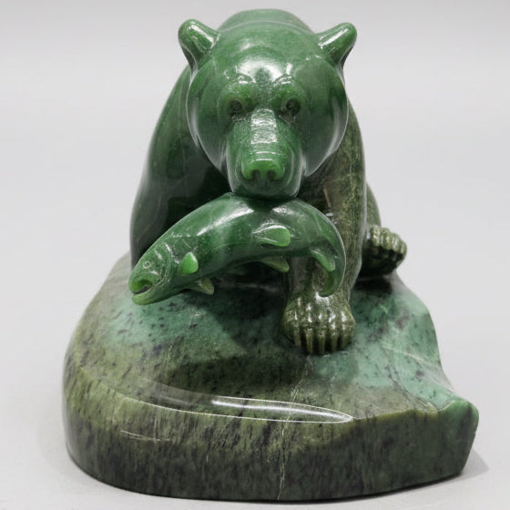 Hand-carved jade stone bear sculpture displayed in a Whistler art gallery.
