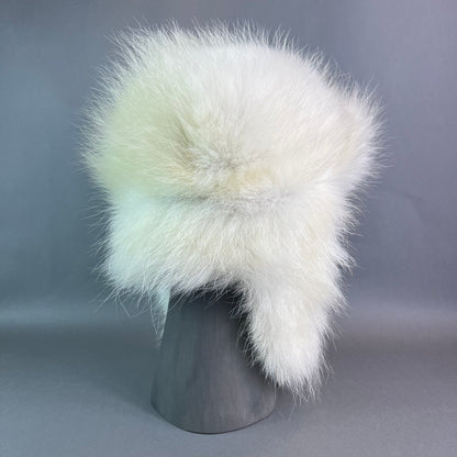 White fur hat on a gray mannequin head against a gray background