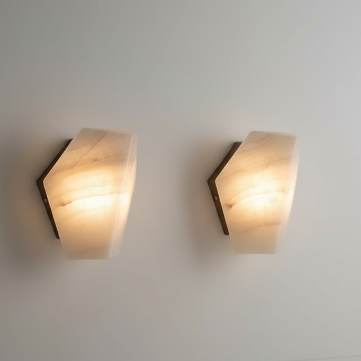 Wall-mounted alabaster sconce light with brass accents, providing illumination to the surrounding area.
