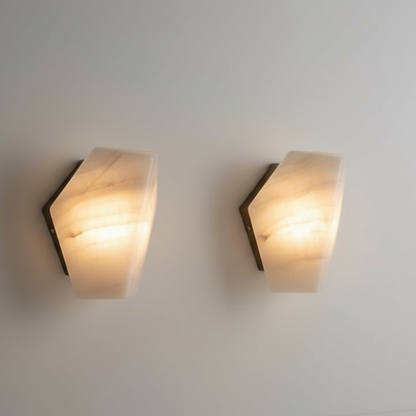 Wall-mounted alabaster sconce light with brass accents, providing illumination to the surrounding area.