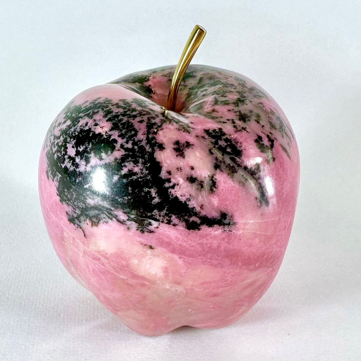 Discover the refined elegance of our Pink Apple—a masterpiece carved from premium British Columbia Pink Rhodonite. This exquisite sculpture showcases the stone's luminous pink depths and silky texture, making it a distinguished addition to any discerning collection. Each piece captures the natural beauty and timeless sophistication that only authentic Pink Rhodonite can deliver. A statement of taste and exclusivity for those who appreciate genuine artistry.
