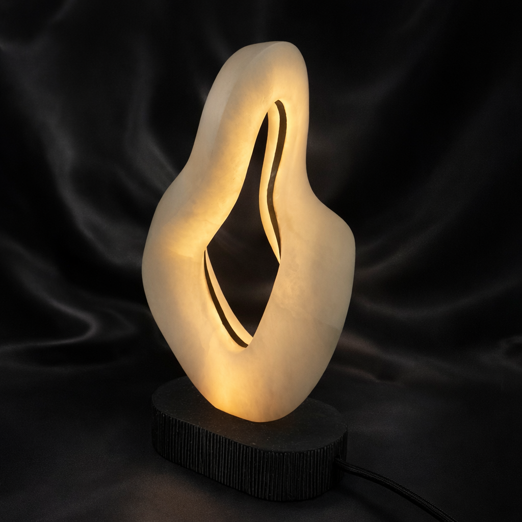 Hand-carved abstract alabaster LED lamp glowing with warm light at Fathom Stone Art Gallery Whistler.