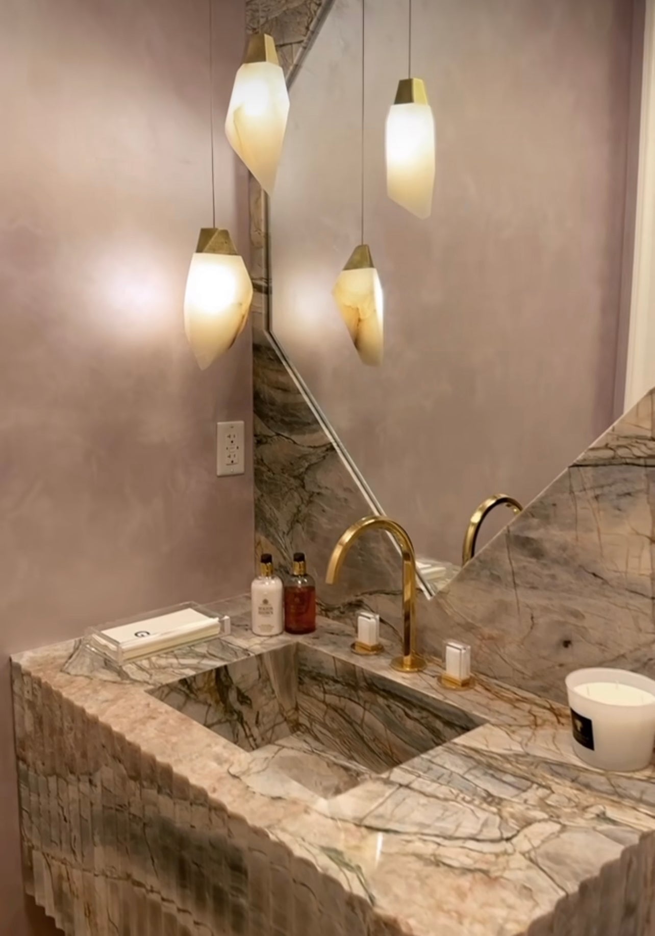 This Randy Zieber Alabaster natural stone with an antique brass set of two pendants looks perfect matching the facet shape on the onyx stone trim mirror. 